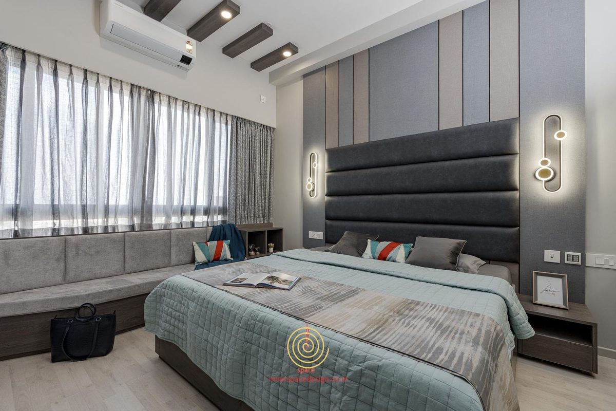 Bedroom with a cushioned window seat running under the window and a dark leather headboard