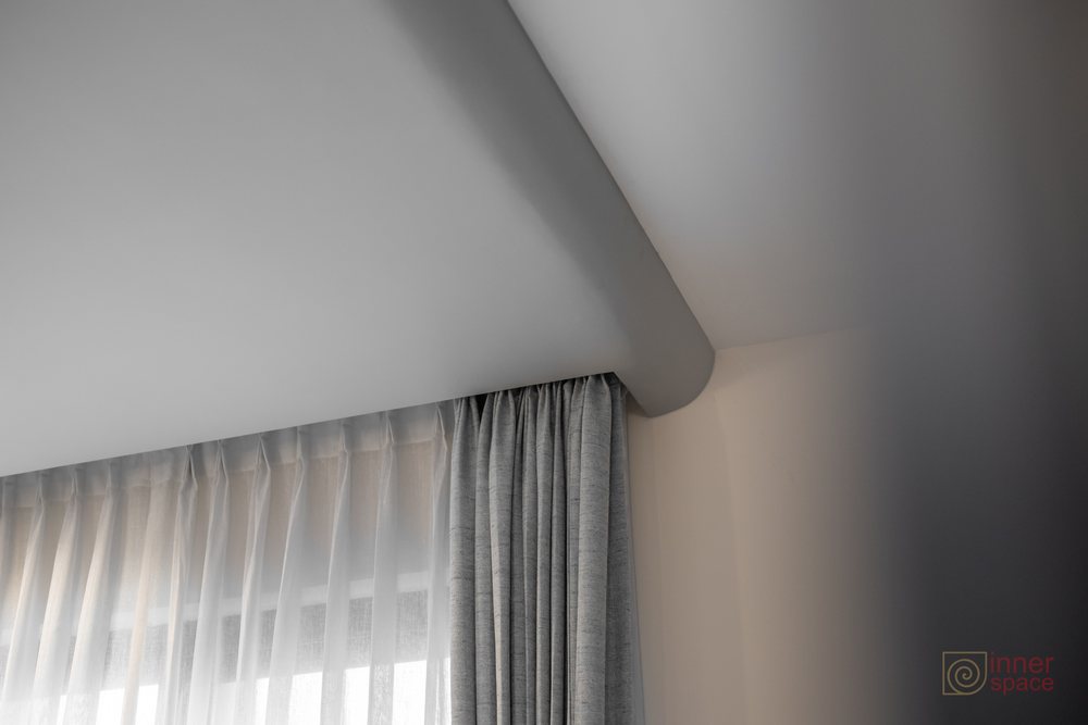 Curtain track recessed into the ceiling so the sheer and textured drapes hang flush