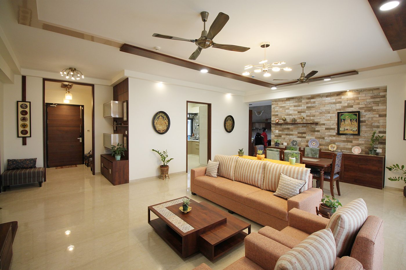 Open living and dining space with a stone-clad feature wall, wood ceiling framing and marble flooring
